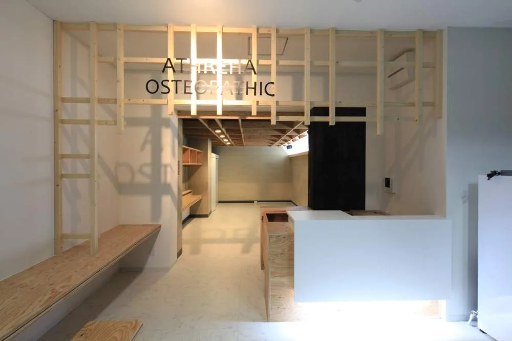 ATHRETIA OSTEOPATHIC 受付 — 合板の構造を見せたあたたかい接骨院