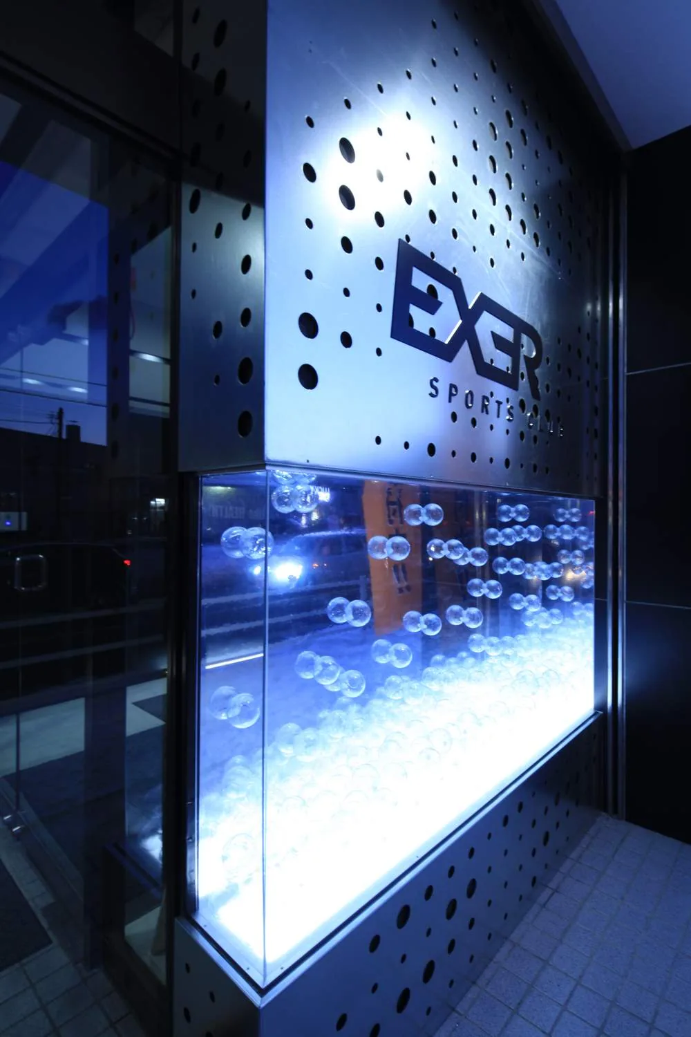 EXER ファサード — パンチング鋼板の発光サイン